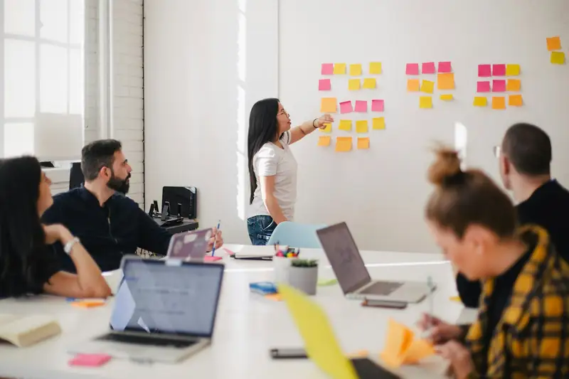 Equipo planeando una estrategia con notas adhesivas en una pared