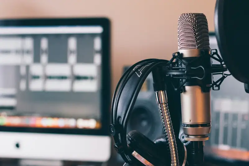 Micrófono de estudio frente a una consola de grabación